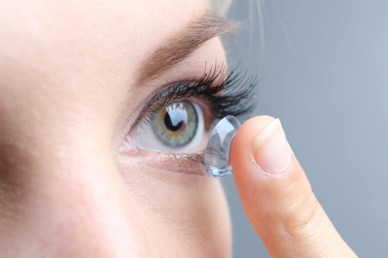 Woman inserting contact lens